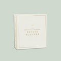 White planner with gold text on a light green background