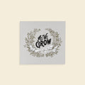 Decorative print with 'As We Grow' text and floral wreath on a light gray background