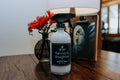 Spray bottle labeled 'Farmer's Daughter' on a wooden surface with a blurred background
