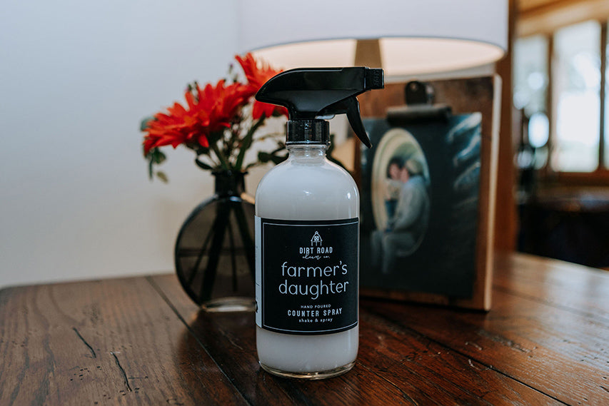 Spray bottle labeled 'Farmer's Daughter' on a wooden surface with a blurred background