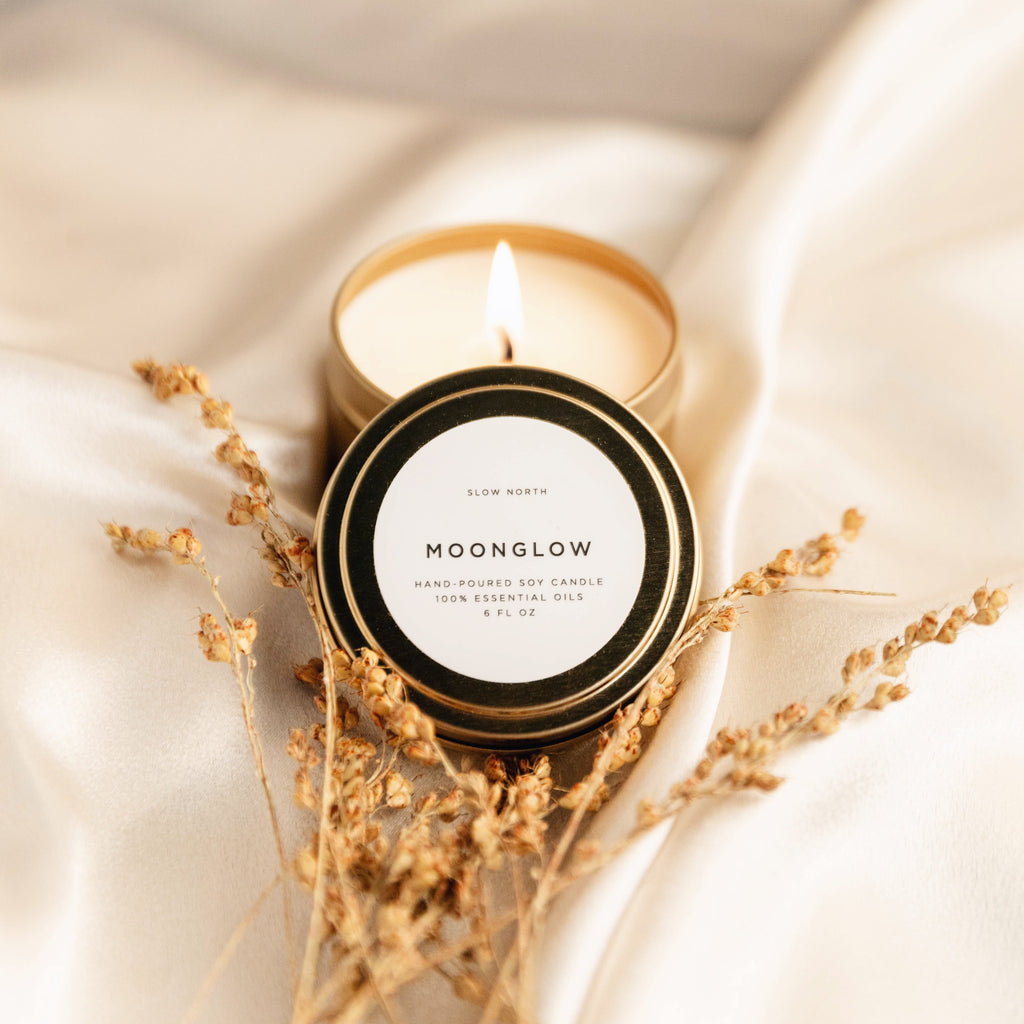 Moonglow candle with a label on a soft fabric background