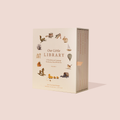 Our Little Library Volume 3: A Traditional Language Vocabulary Book Set by Tapti Puri & Ravi Kulkarni, shown in its cream-colored slipcase box with small illustrated objects around the title, on a solid pale pink background.