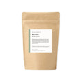 Kraft paper packaging with a label for 'Revive' bath salts from Slow North on a white background